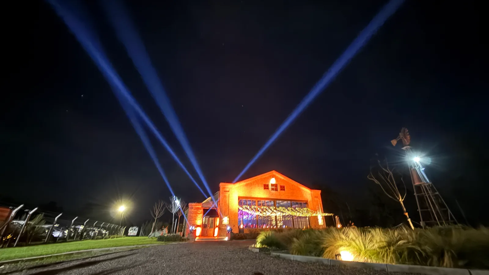 Haces azules sobre un salón iluminado de naranja de noche.