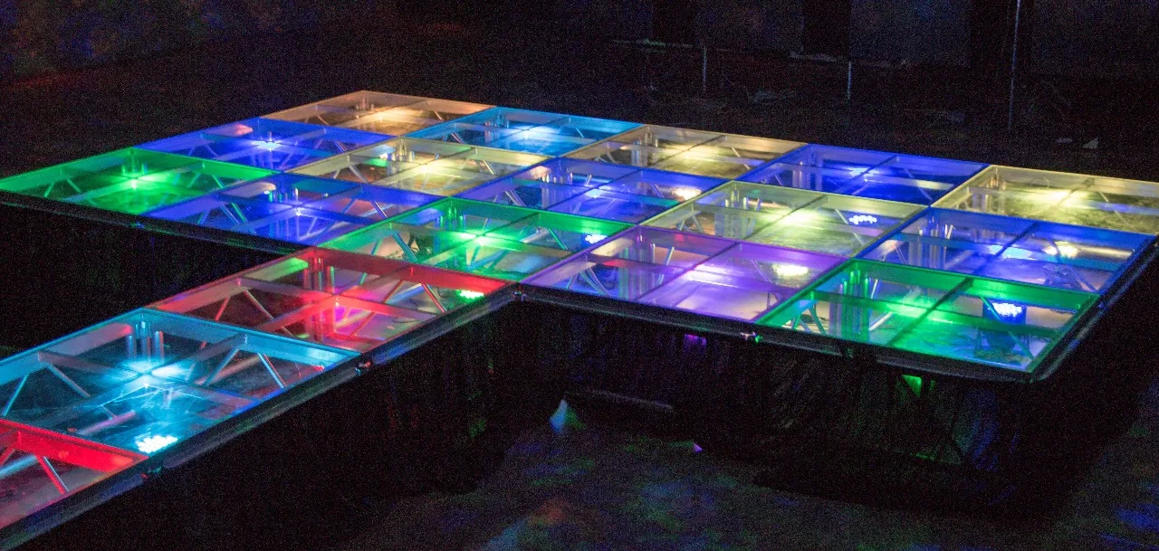 Plataforma transparente con iluminación multicolor bajo la superficie.