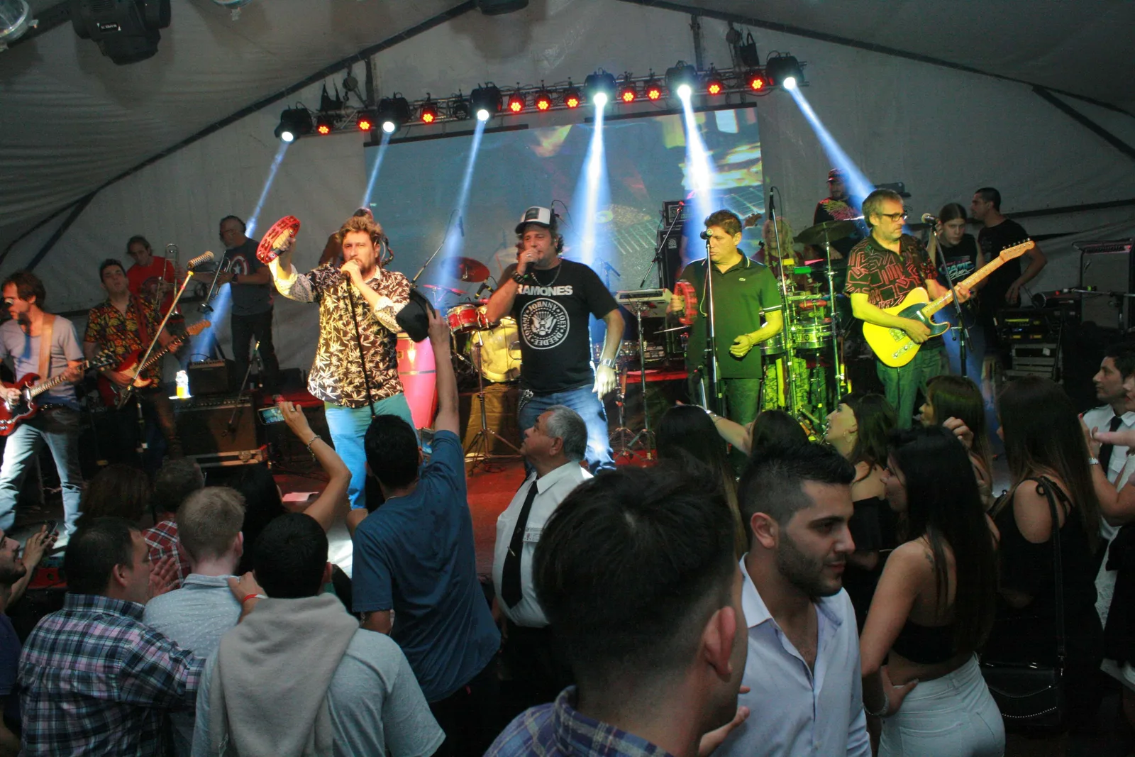 Grupo musical actuando sobre un escenario frente al público.