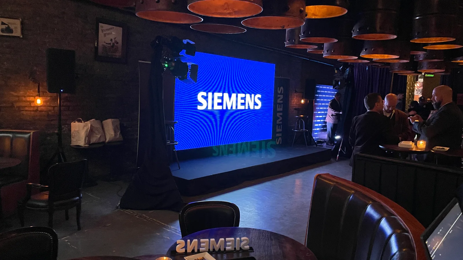Tarima frente a una pantalla con el logo de Siemens.