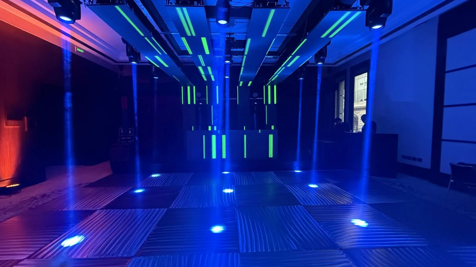 Paneles sobre una pista y una cabina con líneas verdes e iluminación azul.
