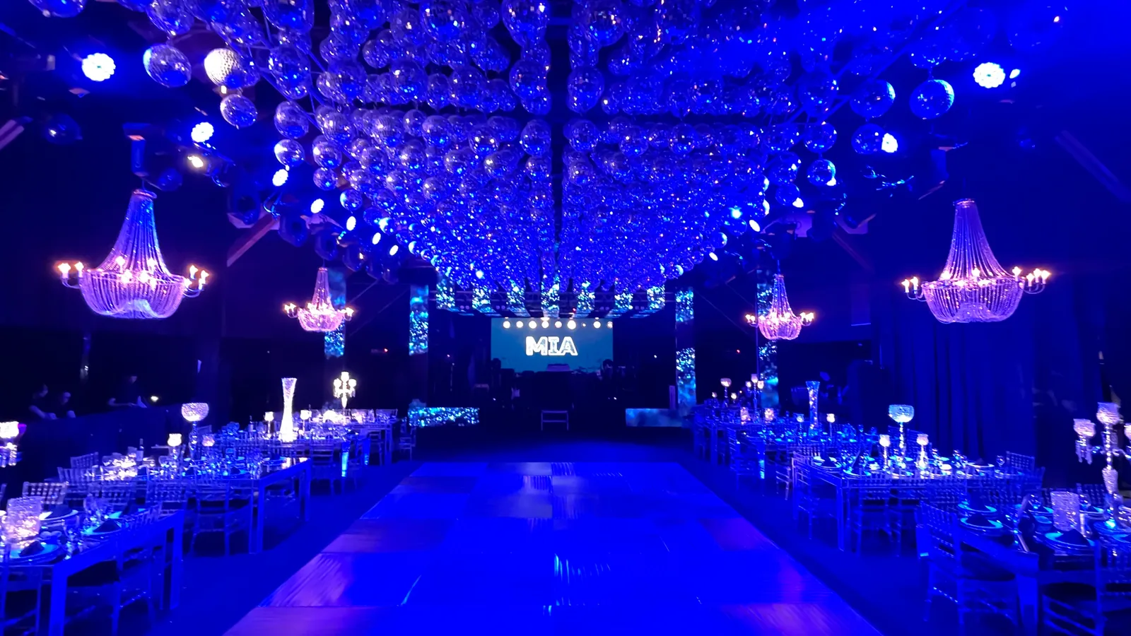 Conjunto de pequeñas esferas espejadas sobre una pista iluminada de azul.